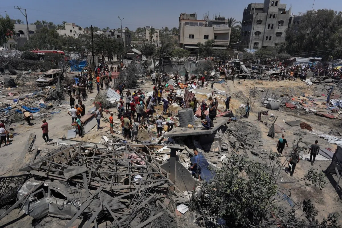 Gazans look at the debris of destroyed tents and makeshift housing structures following an Israeli military strike on the al-Mawasi camp for internally displaced people (IDP), near the city of Khan Yunis, southern Gaza Strip, on July 13, 2024, in which 90 people were reported killed by Gazan health officials. (Bashar Taleb/AFP via Getty Images)