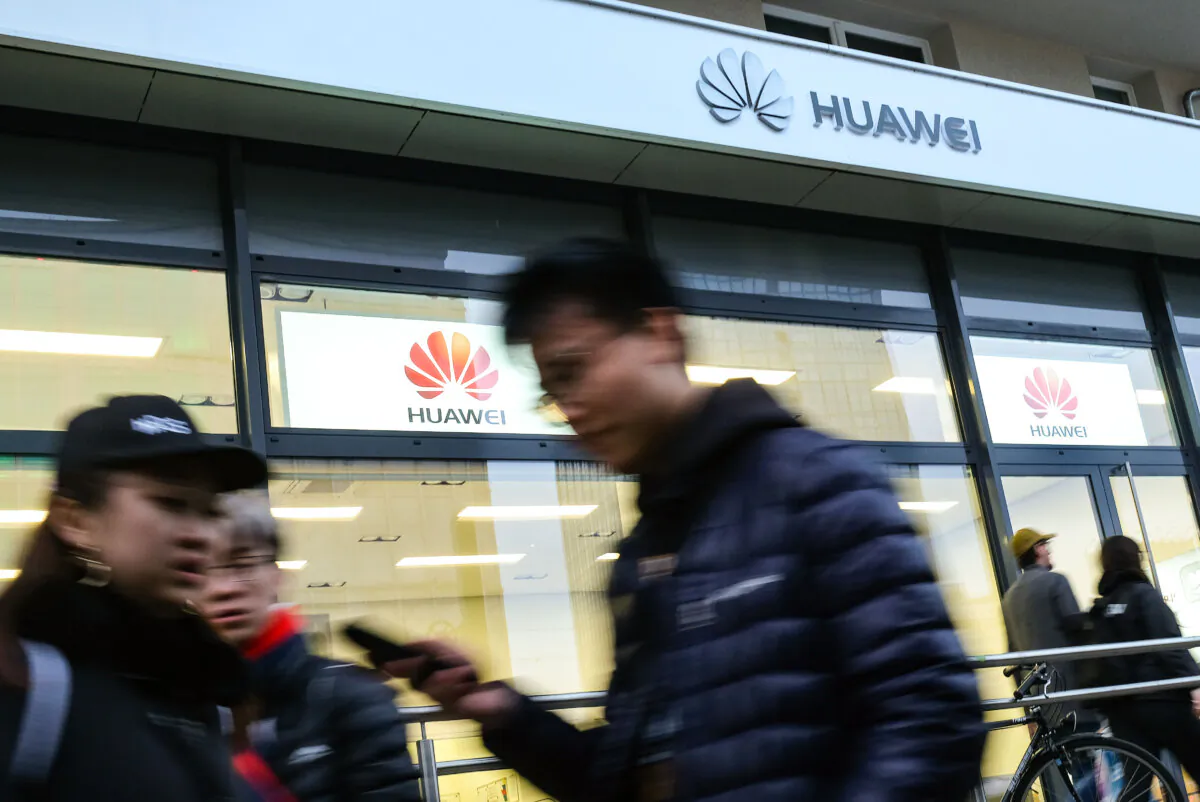 People walk past a Huawei customer service center in Berlin on March 12, 2019. (Sean Gallup/Getty Images)