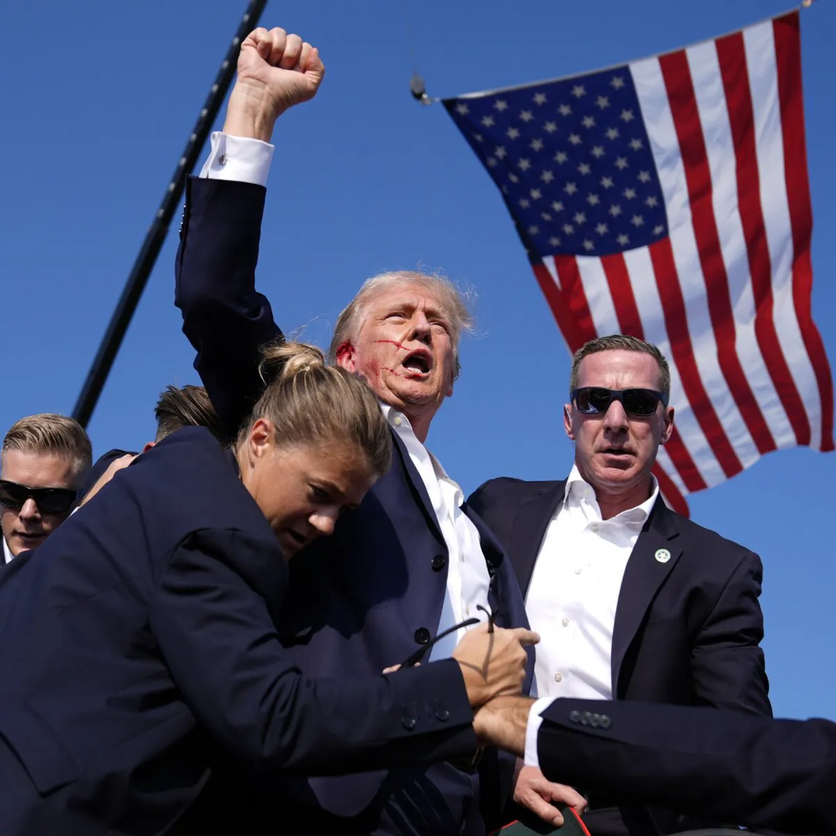 Republican presidential candidate former President Donald Trump is surrounded by Secret Service agents after being shot in the ear in an assassination attempt at a campaign rally in Butler, Pa., on July 13, 2024. (Evan Vucci/AP Photo)