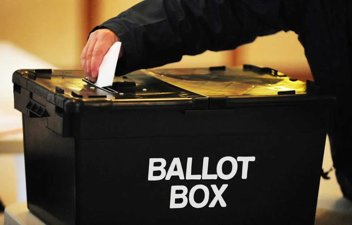 A voter places a ballot paper in the ballot box at a British polling station on May 6, 2010. (Rui Vieira/PA)