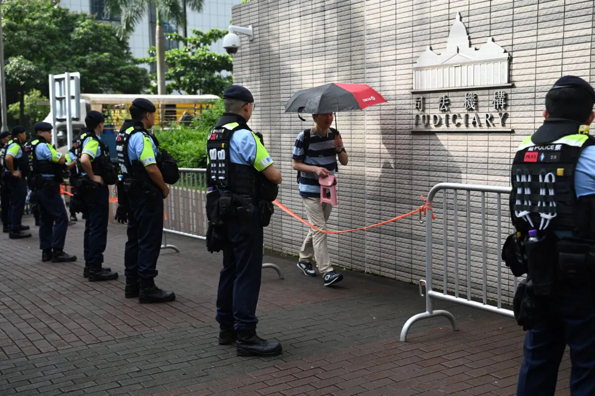 Police watch people entering the West Kowloon Magistrates' Court in Hong Kong on July 5, 2024, where pro- democracy activist Joshua Wong and five others appear for their mitigation session in the biggest case against pro-democracy campaigners known as the 47, since China imposed a national security law to crush dissent. (Peter PARKS / AFP via Getty Images)