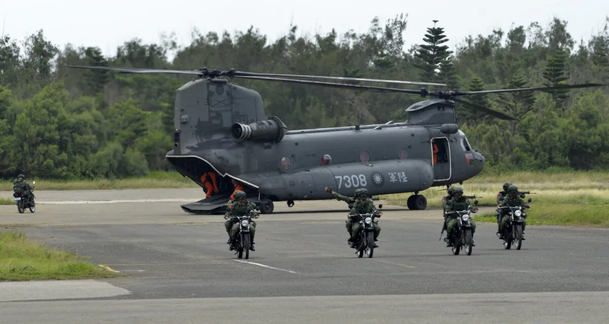 Armed Taiwanese soldiers ride on motorcycles next to a U.S.-made CH-47 helicopter during the "Han Kuang" (Han Glory) life-fire drill, some 4 miles from the city of Magong on the outlying Penghu islands in Taiwan on May 25, 2017. (Sam Yeh/AFP via Getty Images)