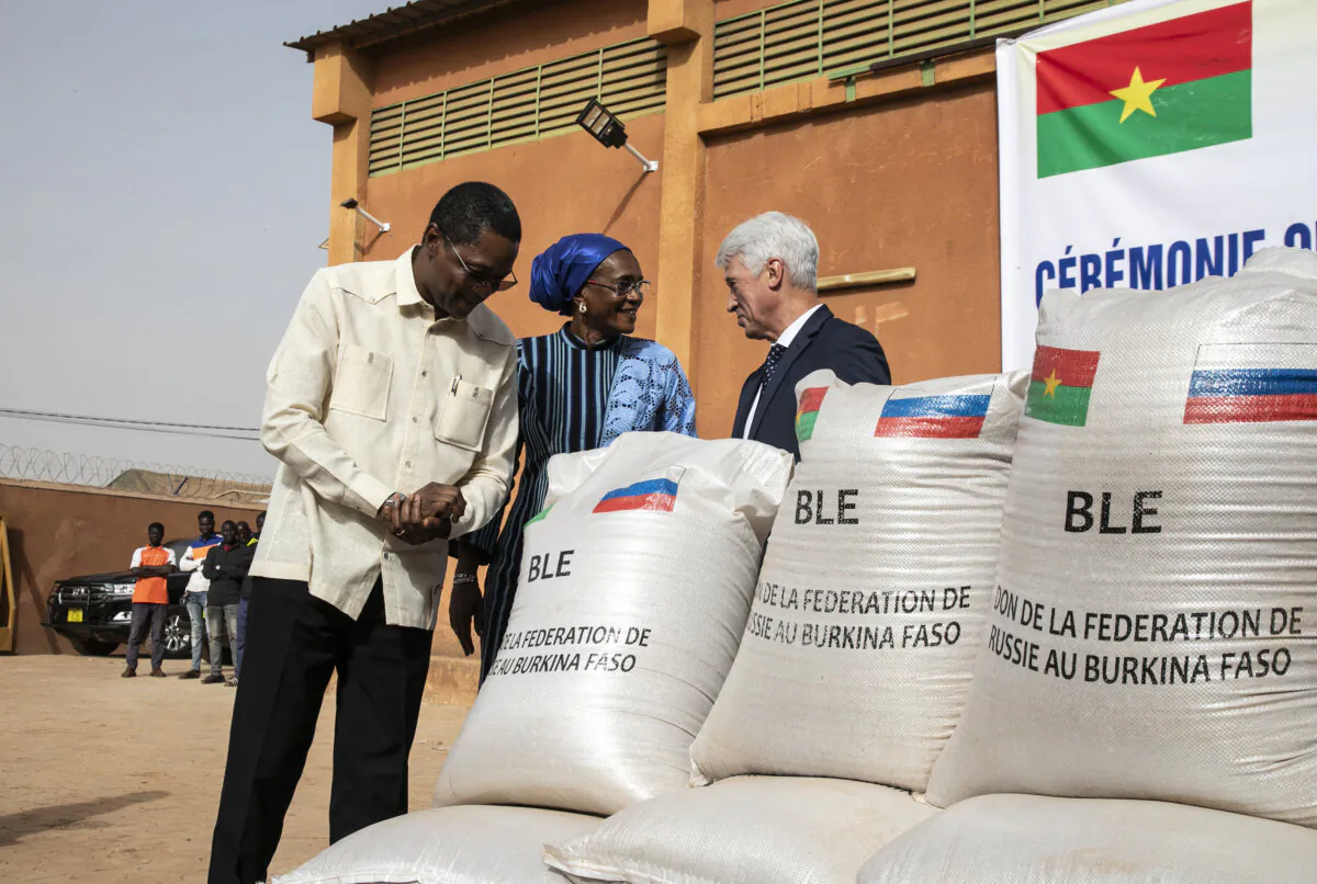 Burkina Faso's Minister of Foreign Affairs Karamoko Jean-Marie Traore (L), Burkina Faso's Minister of Solidarity, Humanitarian Action, National Reconciliation, Gender and Family Nandy Some-Diallo (C) and Russian ambassador to Burkina Faso Aleksei Saltykov (R) talk next to bags of Russian wheat donated to Burkina Faso  in Ouagadougou on Jan. 26, 2024. (Fanny Noaro-Kabre/AFP via Getty Images)