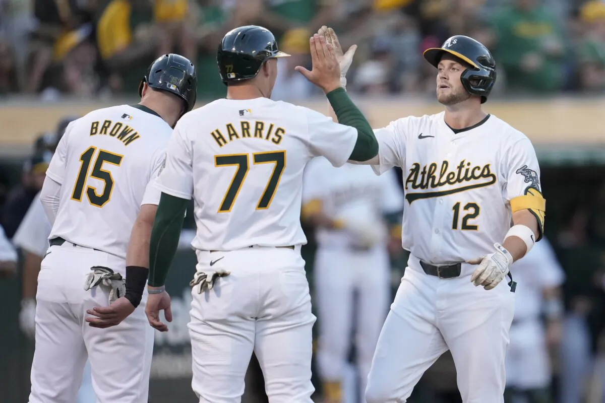Oakland Athletics' Max Schuemann (12) celebrates after hitting a three-run home run that also scored Seth Brown (15) and Brett Harris (77) during the fourth inning of a baseball game against the Los Angeles Angels in Oakland, Calif., on July 19, 2024. (Jeff Chiu/AP Photo)