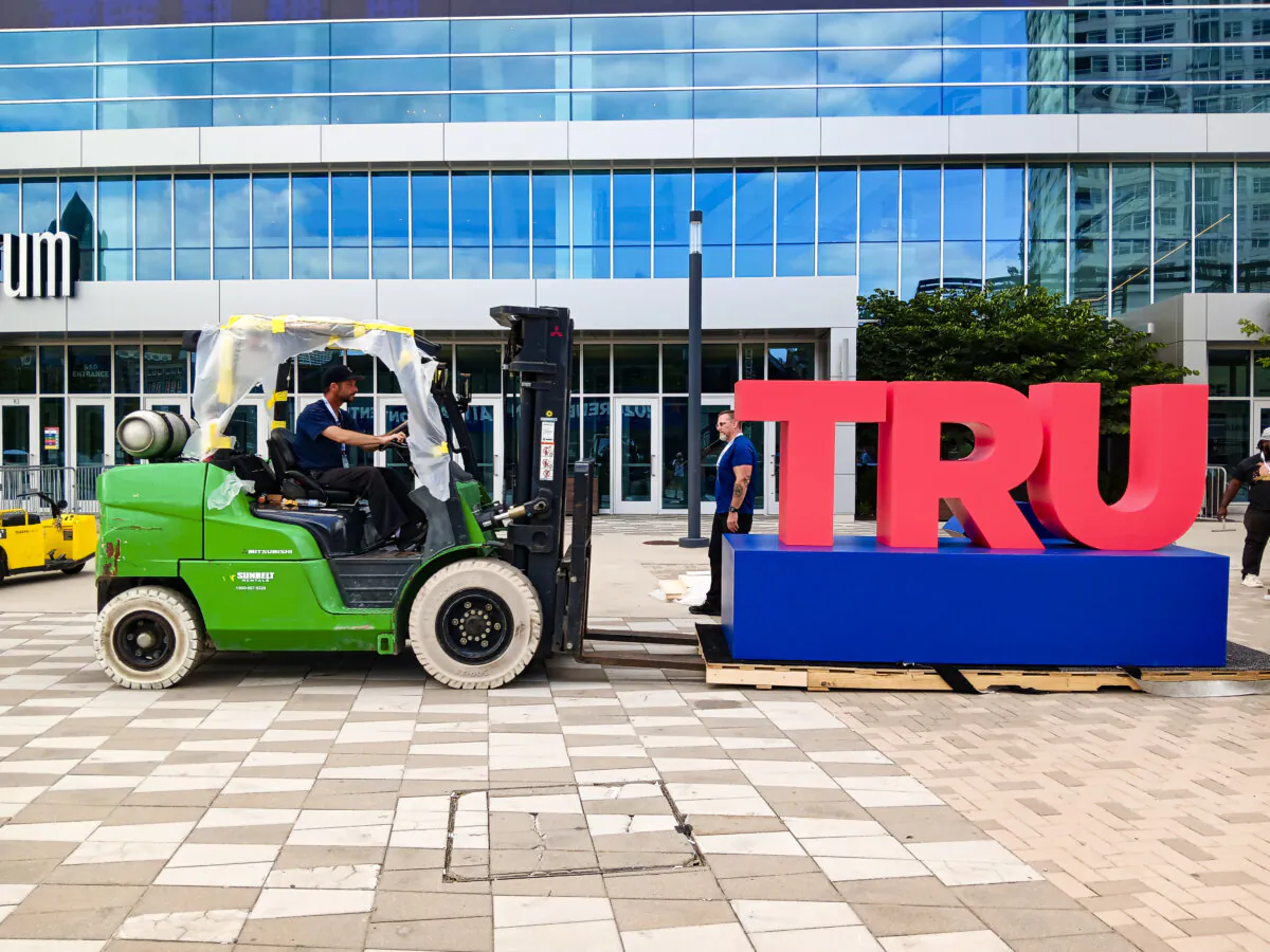 Workers disassemble the words "TRUMP 2024" outside the Fiserv Forum on July 19, 2024, the day after the Republican National Convention concluded. (Nathan Worcester/The Epoch Times)