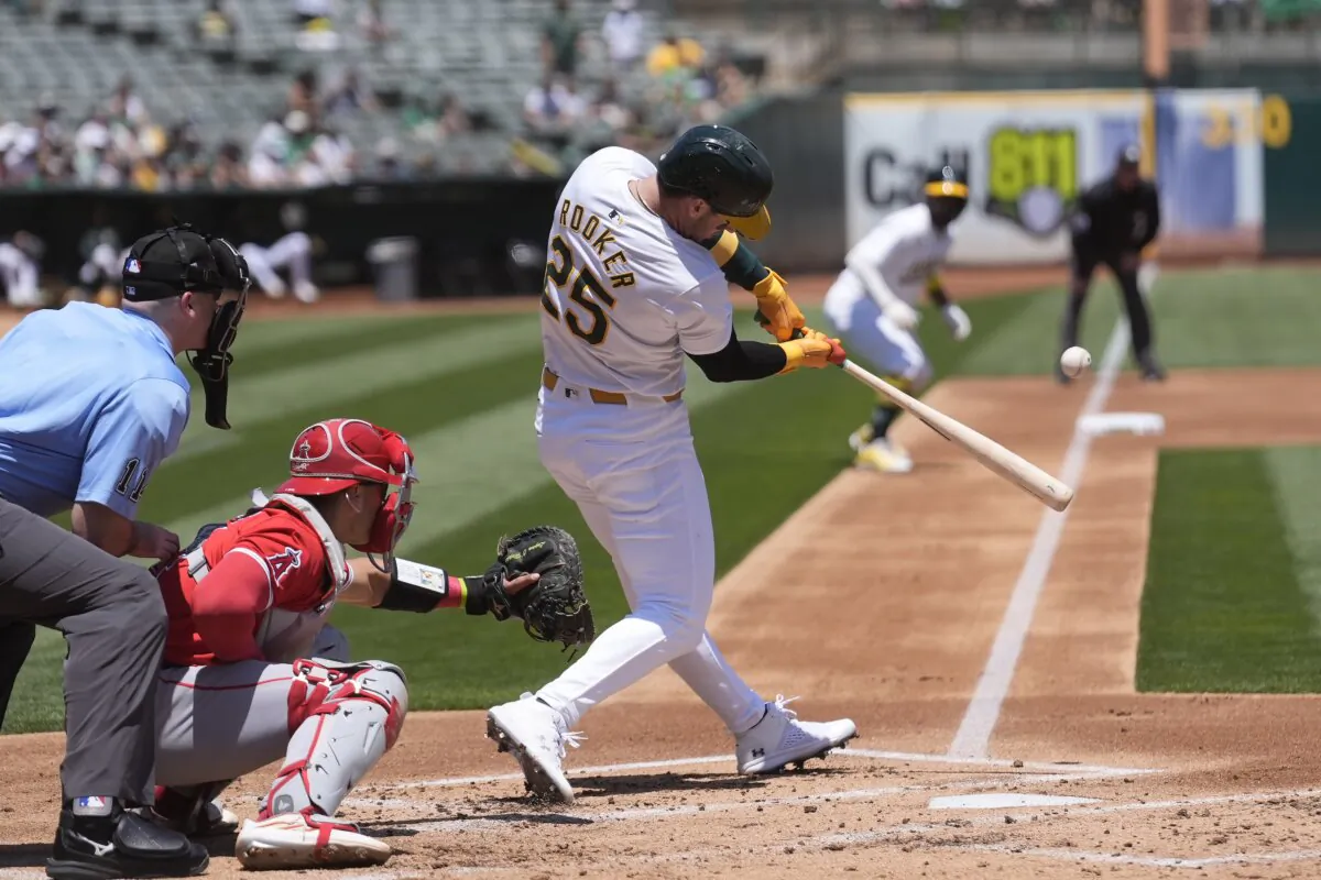 Oakland Athletics' Brent Rooker (25) hits a three-run home run in front of Los Angeles Angels catcher Logan O'Hoppe, second from left, during the first inning of a baseball game in Oakland, Calif., Saturday, July 20, 2024. (AP Photo/Jeff Chiu)