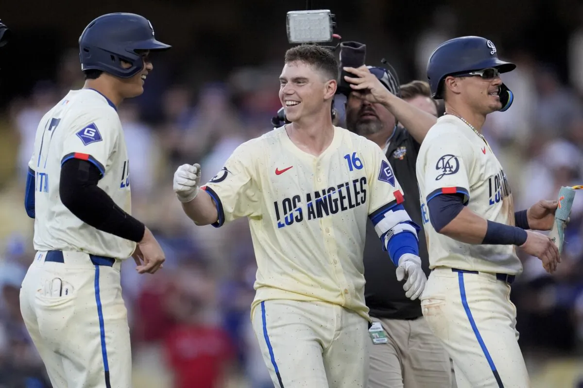 Los Angeles Dodgers' Will Smith (C) celebrates with Shohei Ohtani  (L) and Kiké Hernández (R) after driving in the winning run with a single during the eleventh inning of a baseball game against the Boston Red Sox in Los Angeles on July 20, 2024. (Marcio Jose Sanchez/AP Photo)