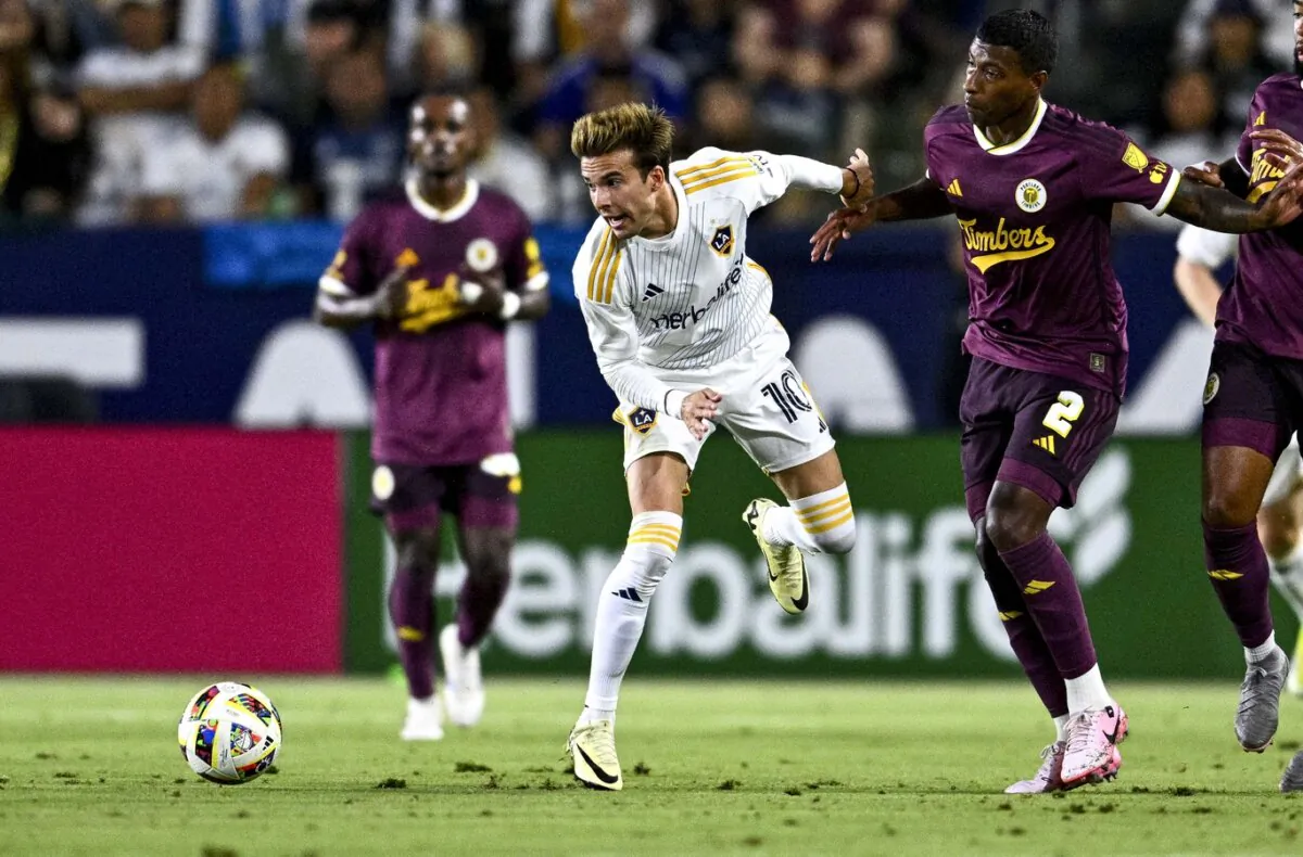 LA Galaxy midfielder Riqui Puig (10) and Portland Timbers defender Miguel Araujo (2) battle for the ball during their MLS soccer match in Carson, Calif., on July 20, 2024. (Kelvin Kuo/USA TODAY Sports via Field Level Media)