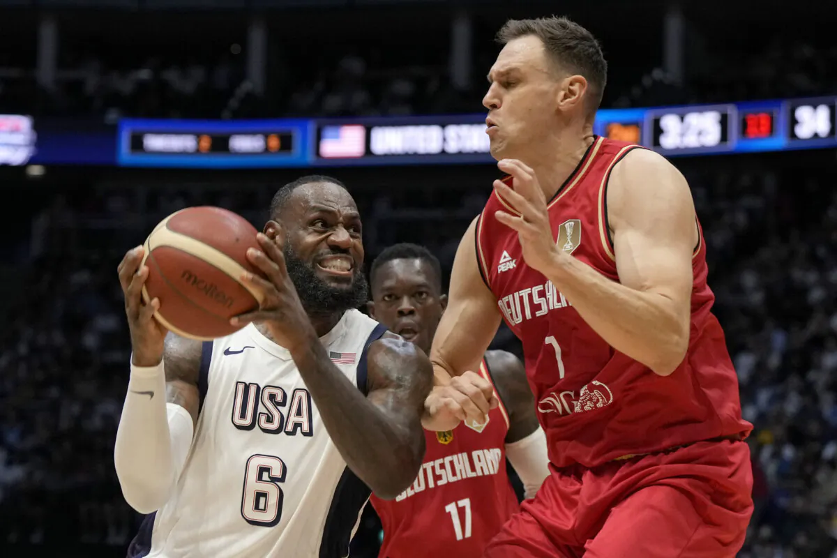 Germany's Johannes Voigtmann (R) defends United States forward LeBron James during an exhibition basketball game in London on July 22, 2024. (Alastair Grant/AP Photo)