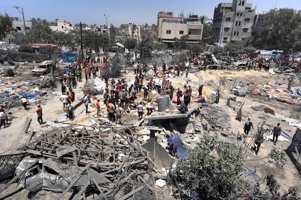 Gazans look at debris following an Israeli military strike near the city of Khan Yunis, southern Gaza Strip, on July 13, 2024.(Bashar Taleb/AFP via Getty Images)