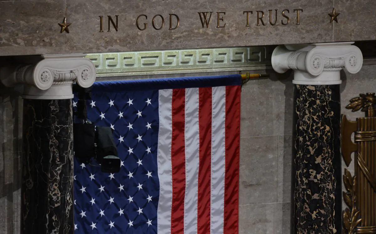 The U.S. flag is draped beneath the words "In God We Trust" in the House Chamber on Capitol Hill, in a file photo. (Jewel Samad/AFP via Getty Images)
