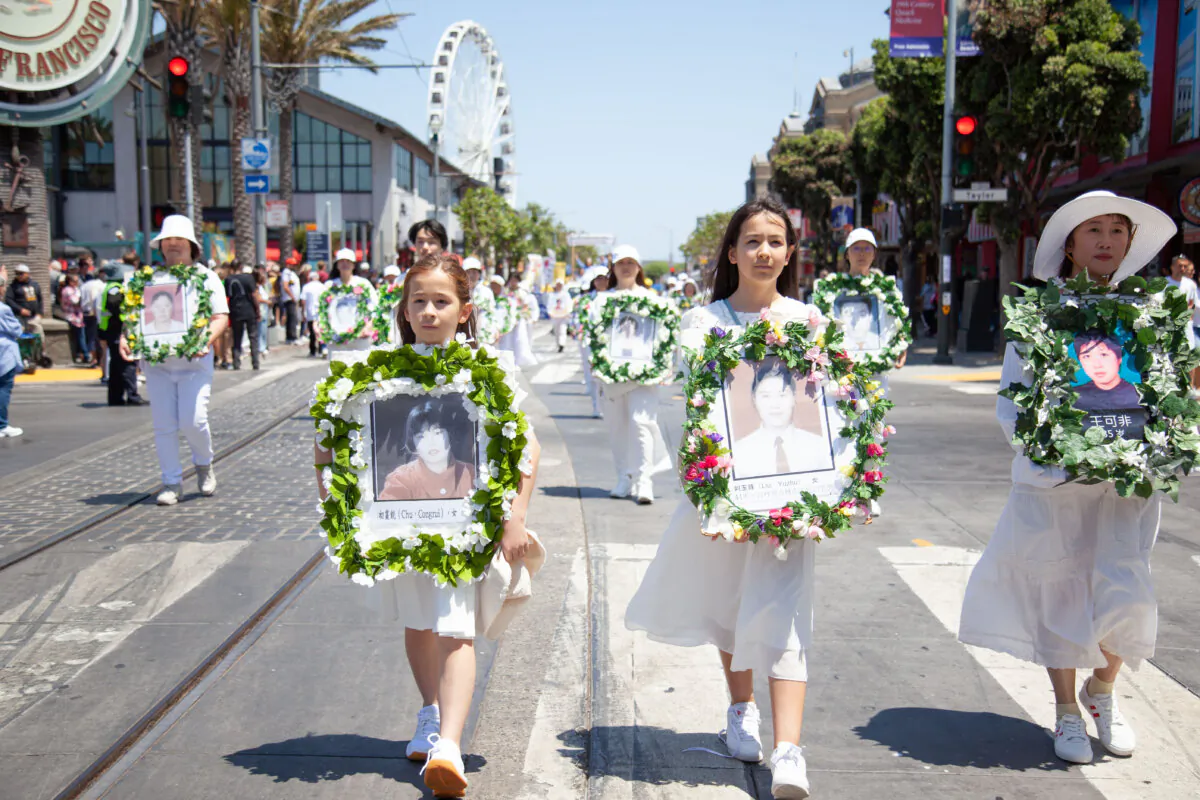 Practitioners hold pictures in remembrance of persecution victims during a parade in San Francisco on July 20, 2024. (Lear Zhou/The Epoch Times)