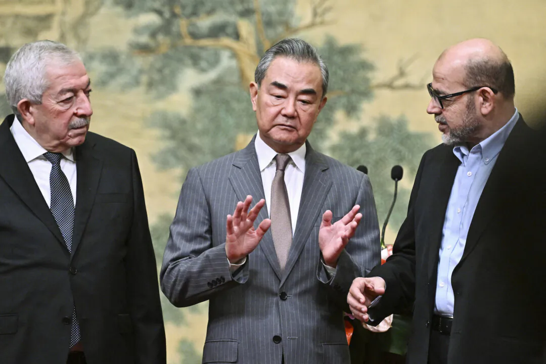 Chinese Foreign Minister Wang Yi (C) hosts an event for Mahmoud al-Aloul (L), vice chairman of Fatah, and Mussa Abu Marzuk (R), a senior member of Hamas, to meet at the Diaoyutai State Guesthouse in Beijing on July 23, 2024. (Pedro Pardo/Pool Photo via AP)
