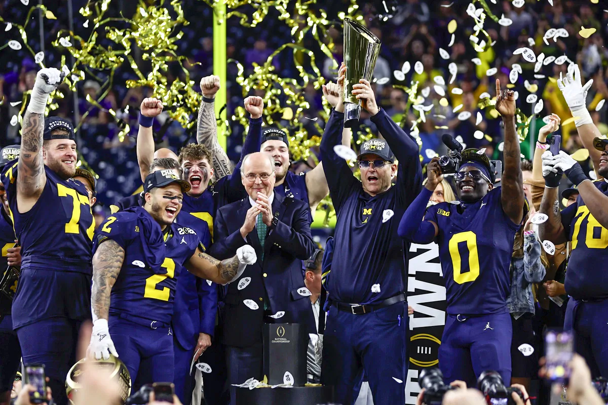 Head coach Jim Harbaugh of the Michigan Wolverines and his team react as he lifts the national championship trophy after defeating the Washington Huskies during the 2024 CFP National Championship game at NRG Stadium  in Houston, Texas., on Jan. 8, 2024. (Maddie Meyer/Getty Images)