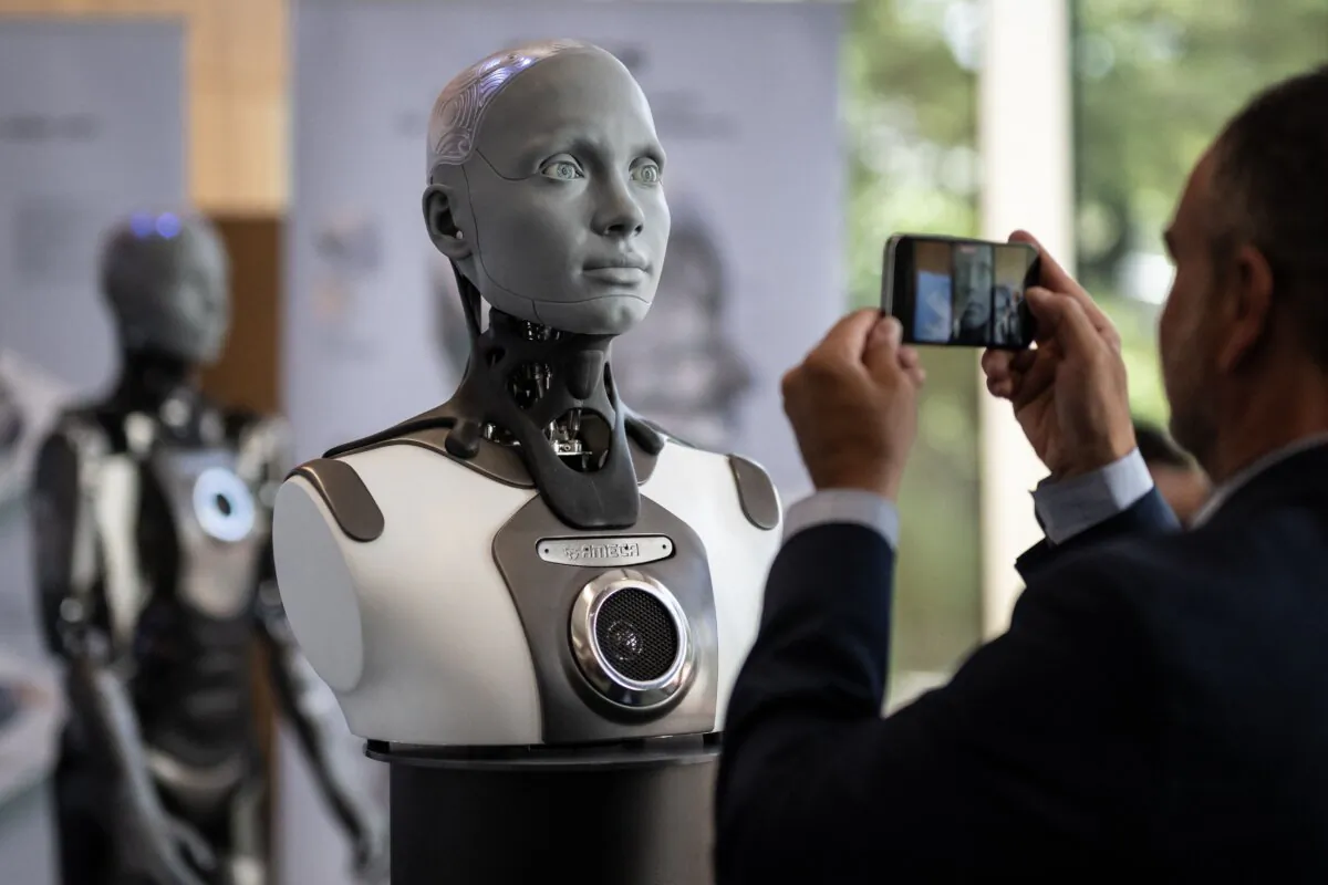 A visitor takes a picture of humanoid AI robot "Ameca" at the booth of Engineered Arts company during the world's largest gathering of humanoid AI Robots as part of International Telecommunication Union AI for Good Global Summit in Geneva, Switzerland, on July 5, 2023. (Fabrice Coferini/AFP via Getty Images)