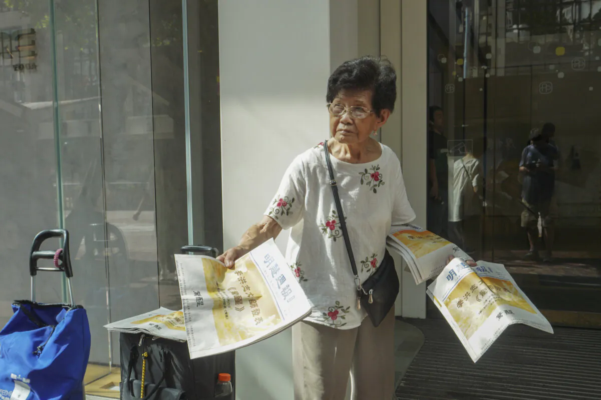 95-year-old Falun Gong practitioner Kitty Jiang is handing out Minghui Weekly on July 9, 2024, in Hong Kong. (Adrian Yu/The Epoch Times)
