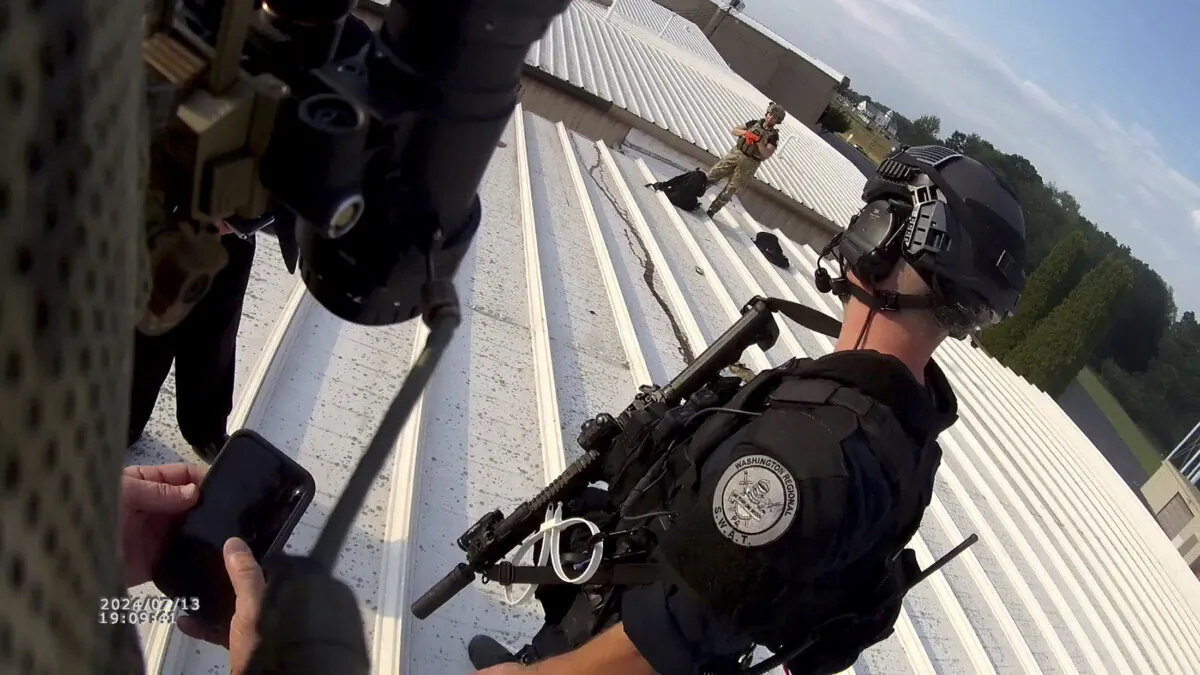 Law enforcement officers stand near the body of a gunman after the assassination attempt on former President Donald Trump during a campaign rally, in Butler, Pa., on July 13, 2024, in this still image taken from bodycam video. (Beaver Co Emergency Services Unit via Chuck Grassley/Handout via Reuters)