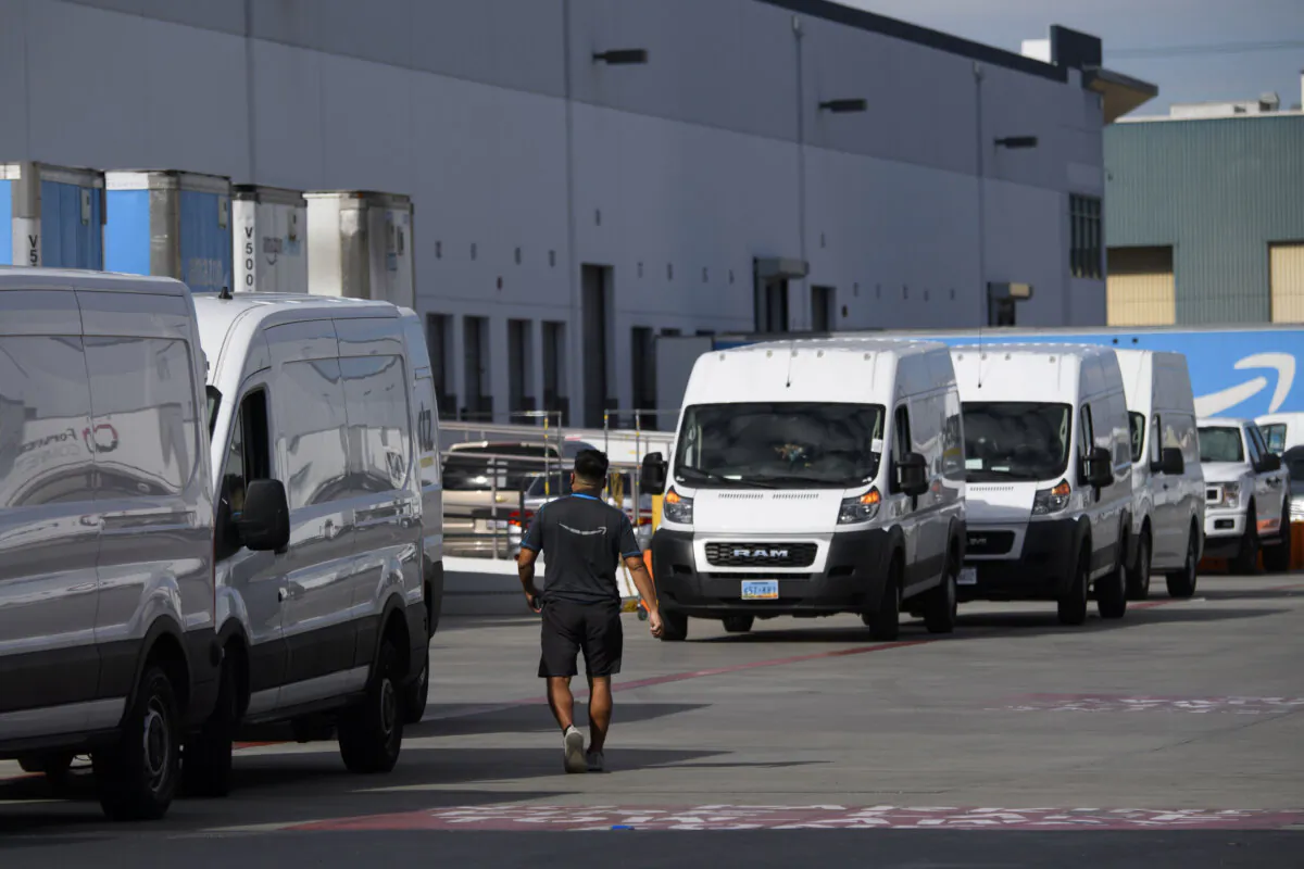 An Amazon delivery driver walks past a row of vans outside of a distribution facility in Hawthorne, Calif., on Feb. 2, 2021. (Patrick T. Fallon/AFP via Getty Images)