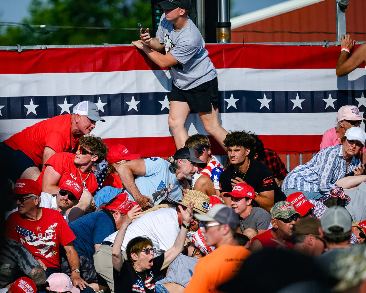 Attendees duck from gunfire at a campaign rally for Republican presidential candidate, former U.S. President Donald Trump at Butler Farm Show Inc. in Butler, Pa., on July 13, 2024. (Jeff Swensen/Getty Images)
