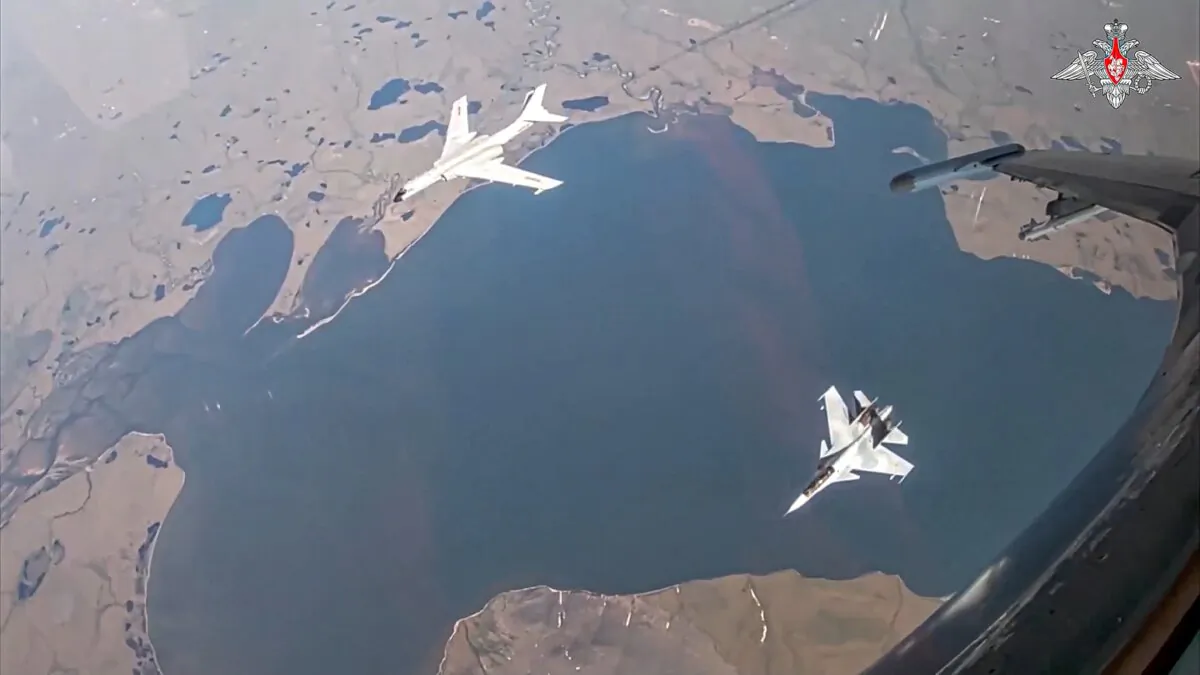 A H-6K long-range bomber of the Chinese air force, upper left, is seen escorted by a Su-30 fighter of the Russian air force during a joint Russia-China air patrol in a still from video released on July 25, 2024. (Russian Defense Ministry Press Service via AP)