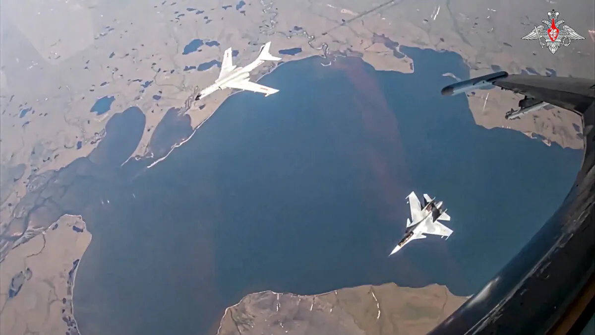 An H-6K long-range bomber of the Chinese air force, upper left, is seen escorted by an Su-30 fighter of the Russian air force during a joint Russia–China air patrol in a still from a video released on July 25, 2024. (Russian Defense Ministry Press Service via AP)