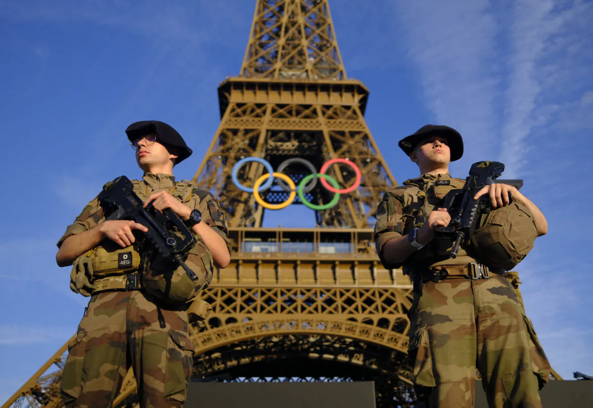 Soldiers patrol on a street in front of the Eiffel Tower ahead of the Olympics Paris 2024 Olympics, in Paris, France, on July 21, 2024. (Stefan Wermuth/Reuters)