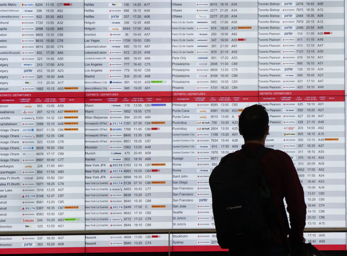 A passenger checks departure times at Trudeau International Airport in Montreal on July 19, 2024. (The Canadian Press/Ryan Remiorz)