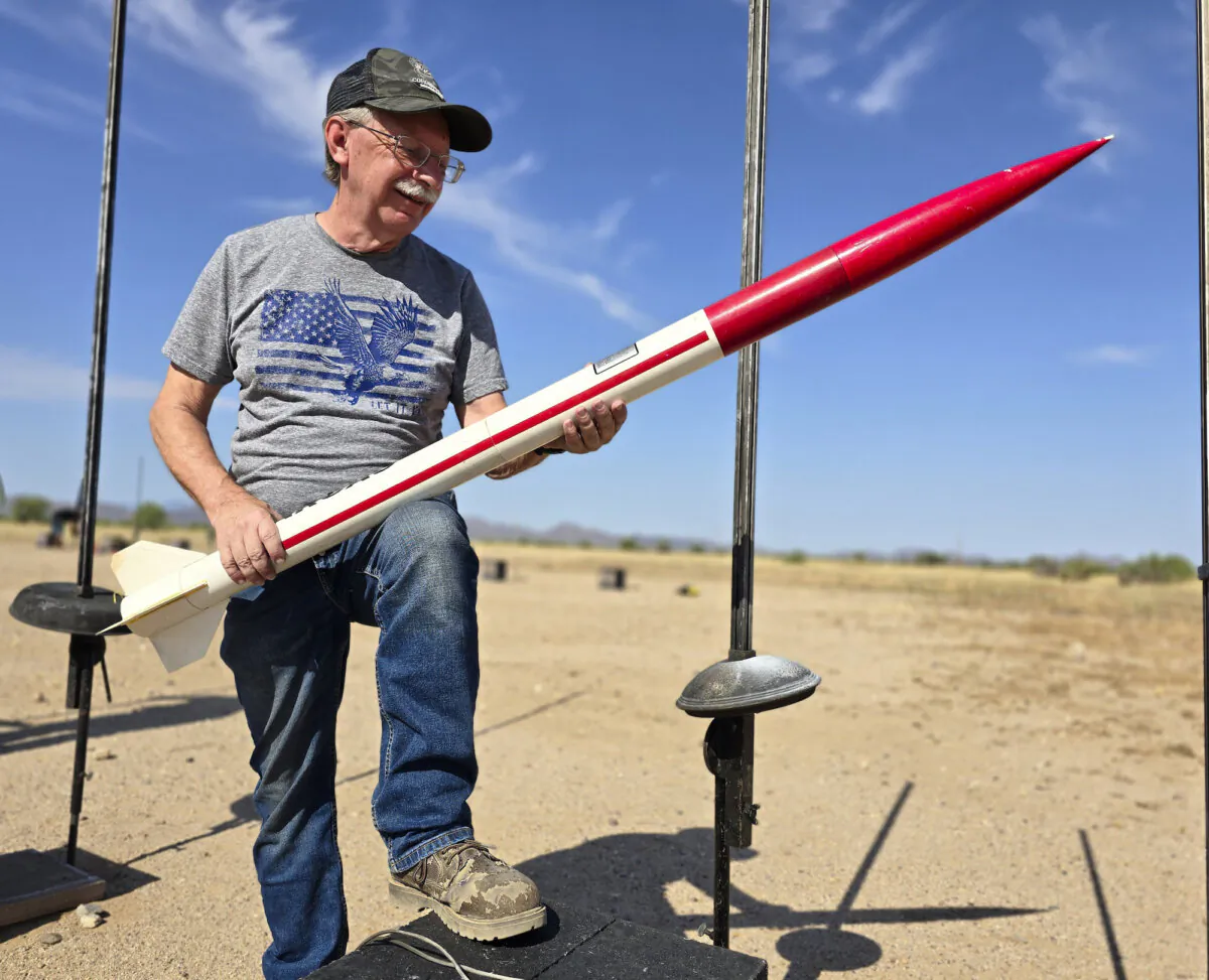 Southern Arizona Rocketry Association member Dan Pate holds the high-powered model rocket he built during a test launch in Marana, Ariz., on July 14, 2024. (Allan Stein/The Epoch Times)