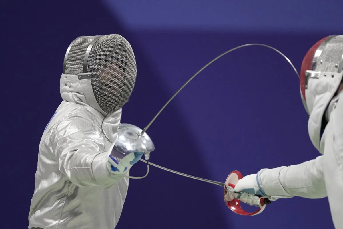 Hungary's Aron Szilagyi, left, and Canada's Fares Arfa compete in the men's individual Sabre round of 32 competition during the 2024 Summer Olympics at the Grand Palais, Saturday, July 27, 2024, in Paris, France. (AP Photo/Andrew Medichini)
