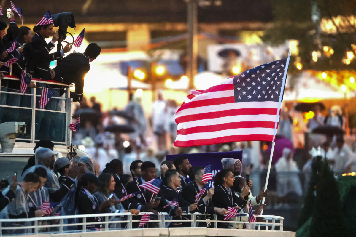 Lebron James, Flagbearer of Team United States, is seen waving their flag on a boat with team mates along the River Seine during the opening ceremony of the Olympic Games Paris 2024 in Paris on July 26, 2024 . (Steph Chambers / POOL / AFP via Getty Images)