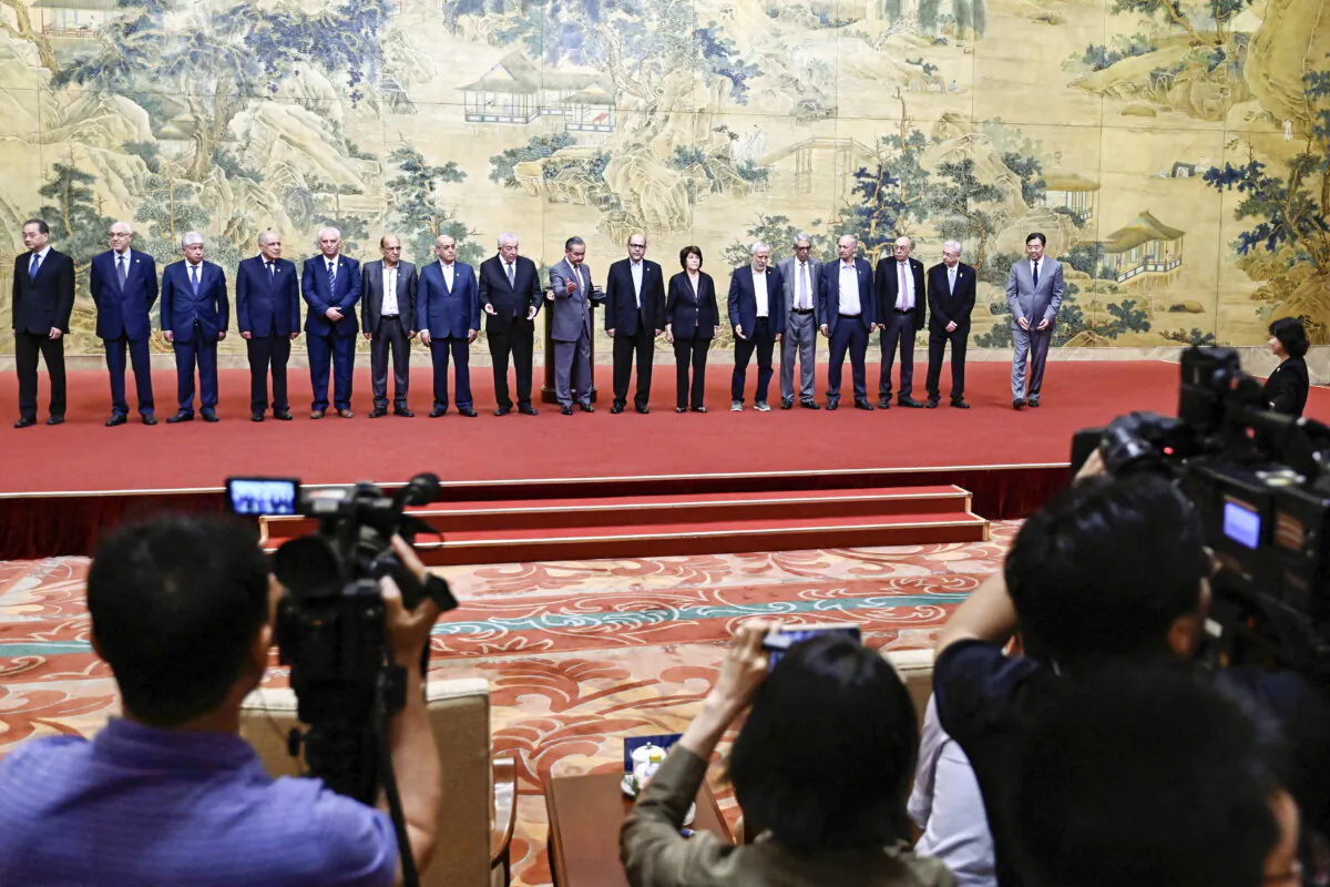 China's Foreign Minister Wang Yi (C) poses for a group picture with members of the Palestinian factions during the signing of the "Beijing Declaration" at the Diaoyutai State Guesthouse in Beijing on July 23, 2024. (Pedro Pardo/Pool/AFP via Getty Images)