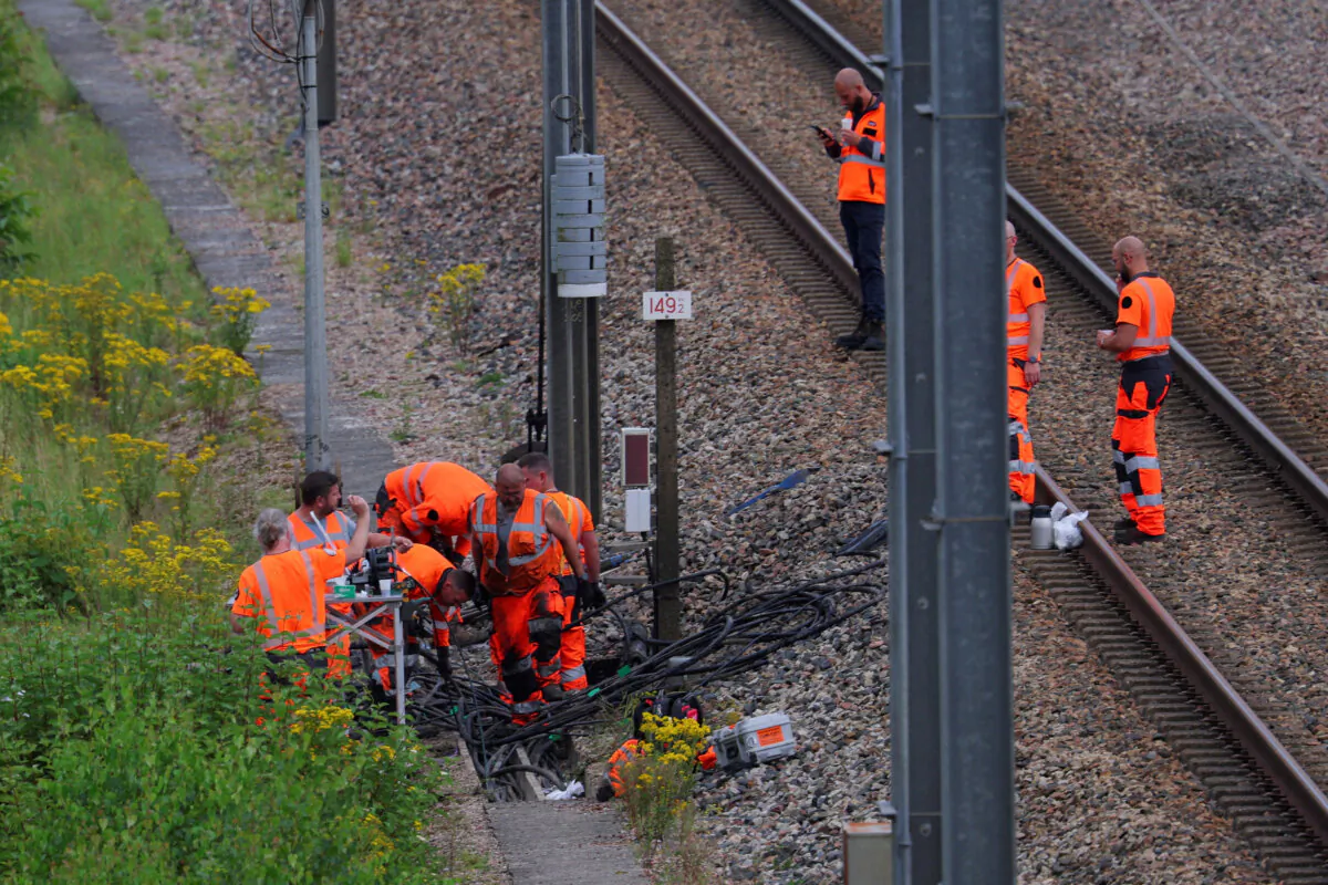 SNCF railway workers and law enforcement officers work at the site where vandals targeted France's high-speed train network with a series of coordinated actions that brought major disruption, in Croisilles, northern France, on July 26, 2024. (Brian Snyder/Reuters)