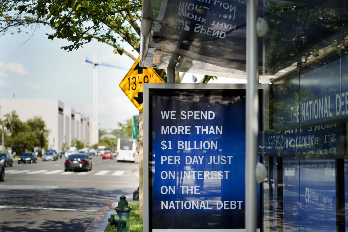 The National Debt Clock is seen at a bus stop in Washington on July 31, 2023. (Madalina Vasiliu/The Epoch Times)