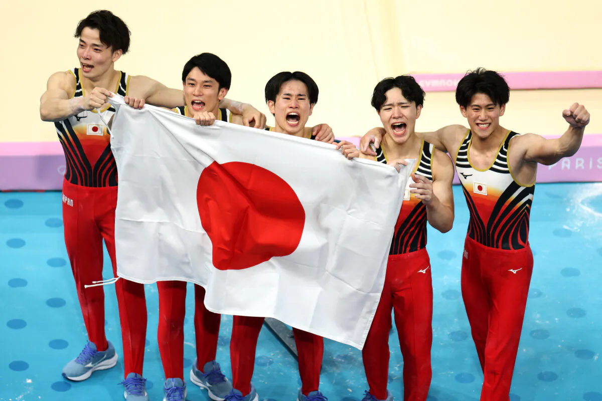 (L–R) Takaaki Sugino, Wataru Tanigawa, Kazuma Kaya, Shinnosuke Oka, and Daiki Hashimoto of Team Japan celebrate after winning gold during the Artistic Gymnastics Men's Team Final on day three of the Olympic Games Paris 2024 at Bercy Arena in Paris, France, on July 29, 2024. (Hannah Peters/Getty Images)