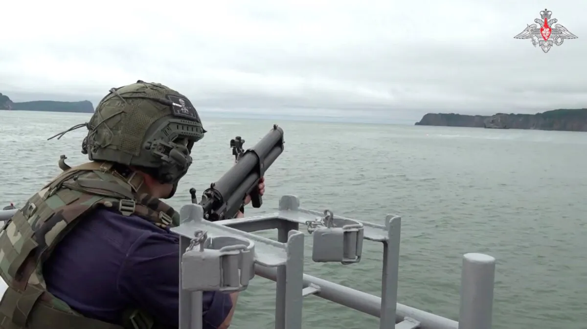 A Russian service member fires from aboard a warship during naval exercises at an undisclosed location, in this still image from a video released on July 30, 2024. (Russian Defense Ministry/Handout via Reuters)