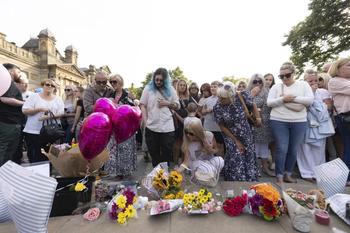 Members of the public take part in a vigil near the scene in Hart Street in Southport, England, on July 30, 2024, where three children died and eight were injured in a knife attack during a Taylor Swift event at a dance school on Monday. (James Speakman/PA via AP)