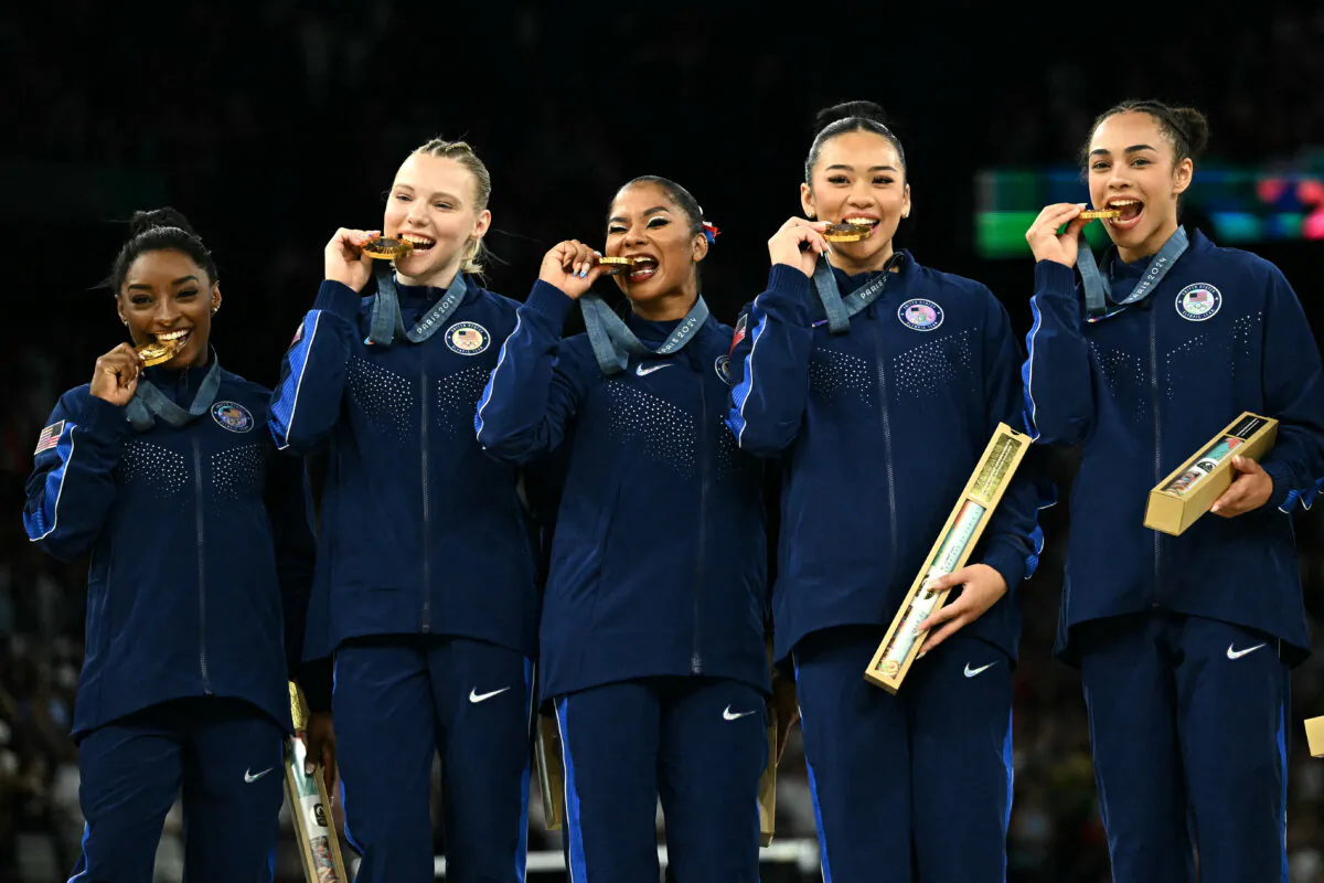 The United States' Simone Biles (L) and teammates pose with the gold medal during the podium ceremony for the artistic gymnastics women's team final during the Paris 2024 Olympic Games at the Bercy Arena in Paris on July 30, 2024. (Lionel Bonaventure/AFP)