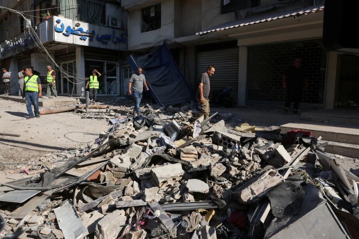 People walk on the rubble of a damaged site the day after an Israeli strike, in Beirut's southern suburbs, Lebanon, on July 31, 2024. (Mohamed Azakir/Reuters)