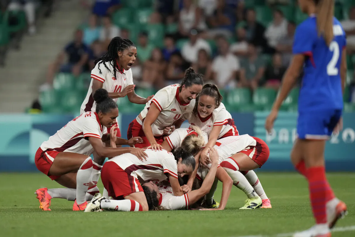 Canada's players celebrate after Vanessa Gille (bottom C), scored her side's second goal during the women's Group A soccer match between Canada and France at Geoffroy-Guichard stadium during the 2024 Summer Olympics in Saint-Etienne, France, on July 28, 2024. (The Associated Press/Silvia Izquierdo)