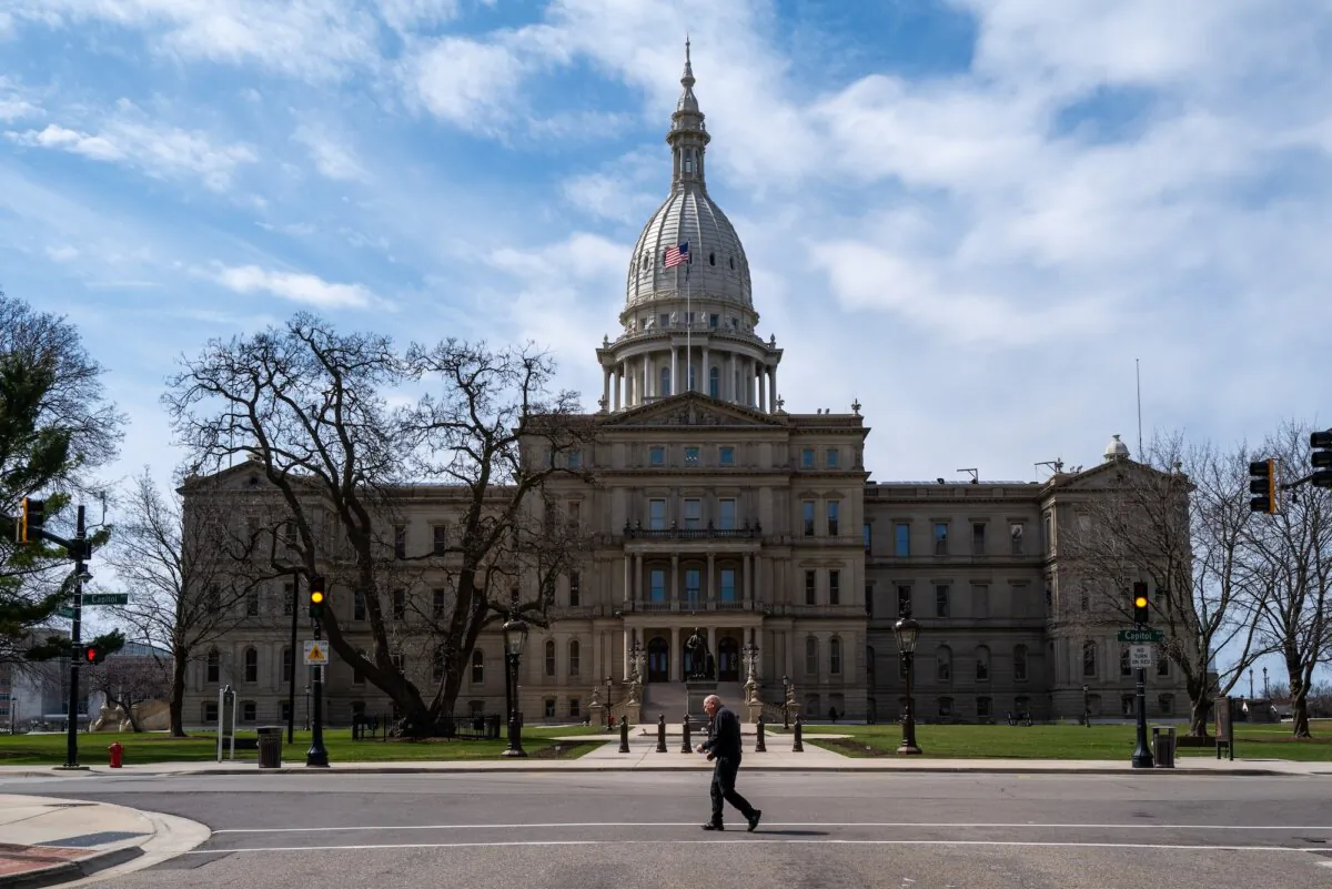 A man crosses the street in front of the Michigan State Capitol building in Lansing, Mich., on April 1, 2024. (Spencer Platt/Getty Images)