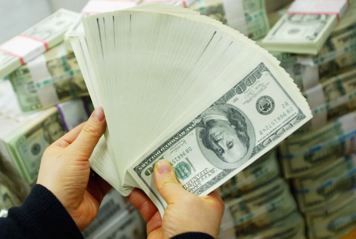 A South Korean banker carries U.S. dollar bank notes at the Korea Exchange Bank in Seoul, South Korea, on Feb. 22, 2005. (Chung Sung-jun/Getty Images)