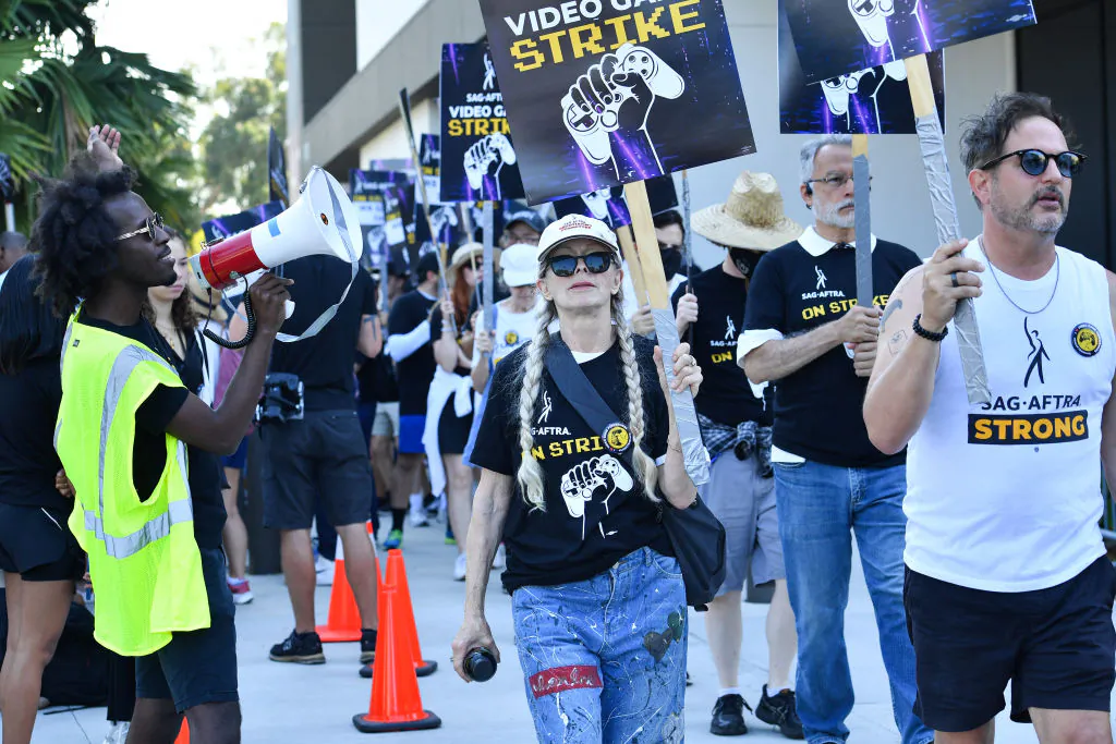 US actress Frances Fisher (C) strikes with SAG-AFTRA union video game performers outside Warner Bros. Games, part of the Global Streaming and Interactive Entertainment unit of Warner Bros. Discovery, in Burbank, California, on August 1, 2024. Artificial intelligence was key to 2023's Hollywood strikes, and it has now sparked a second walkout by those actors who work in a far larger industry, video games. The union on July 26, 2024, began its second strike in nine months, this time against gaming giants that dominate an industry which grosses well over $100 billion each year. (Photo by VALERIE MACON / AFP) (Photo by VALERIE MACON/AFP via Getty Images)