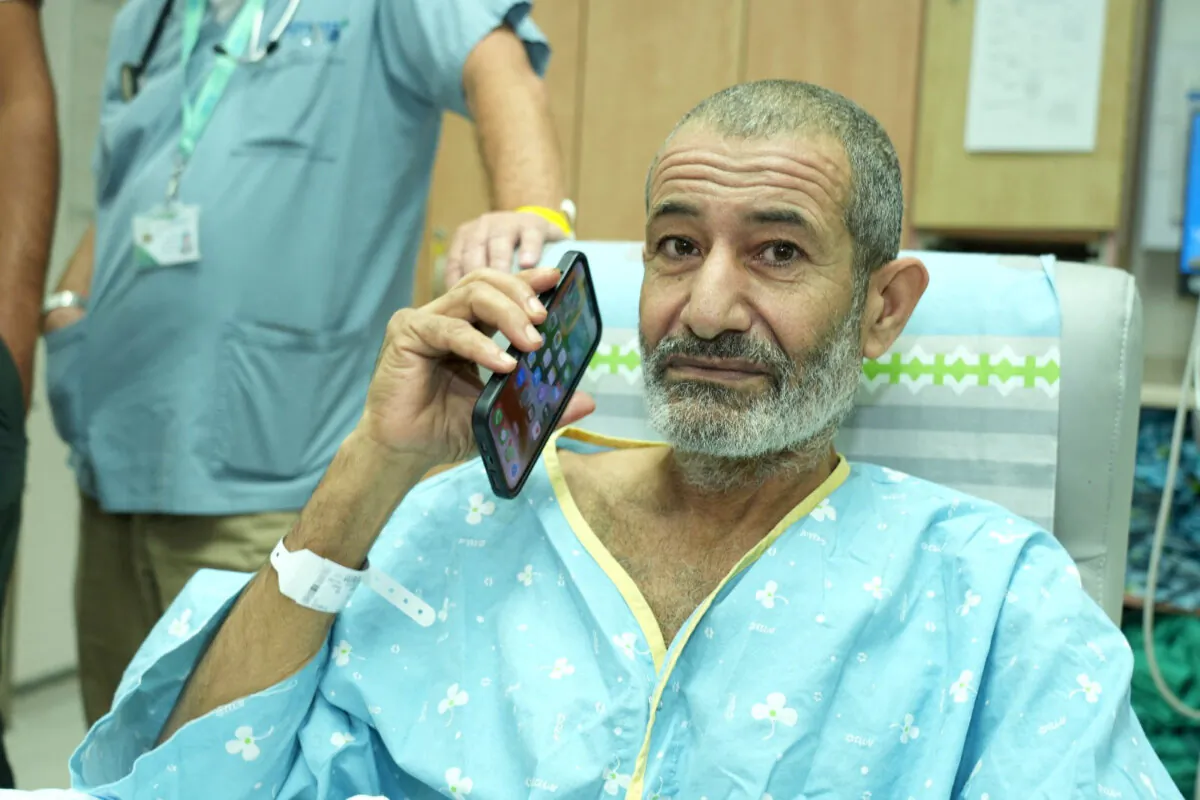 Qaid Farhan Alkadi, a Bedouin Israeli hostage who was kidnapped in the deadly Oct. 7 Hamas attack, uses his phone as he is reunited with loved ones after being rescued from Gaza by Israeli forces, at Soroka Medical Center in Beersheba, Israel, on August 27, 2024. (Courtesy of the Government Press Office/Yossi Ifergan/Handout via Reuters)
