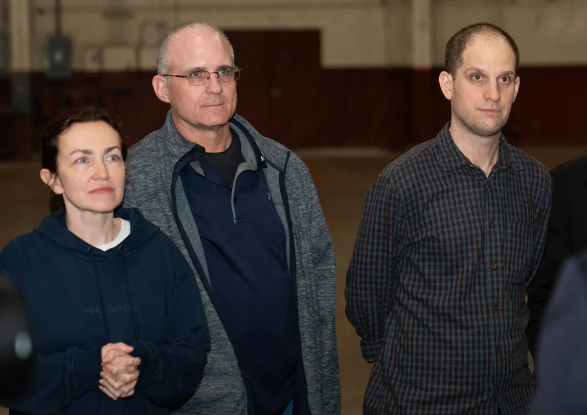 Former prisoners released by Russia, U.S. journalist Evan Gershkovich (R), former U.S. marine Paul Whelan (C), and U.S.-Russian journalist Alsu Kurmasheva (L) stand after landing at Joint Base San Antonio-Kelly Field, Texas, on Aug. 2, 2024. (Suzanne Cordeiro/AFP via Getty Images)
