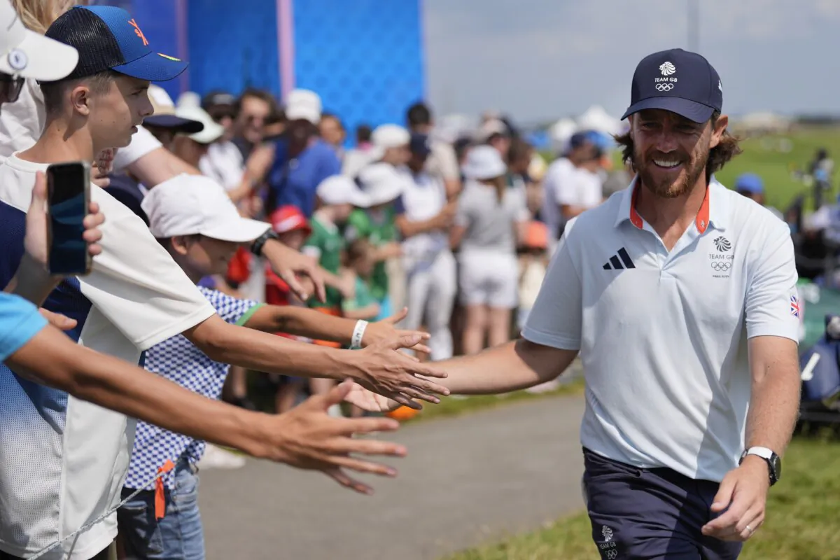 Tommy Fleetwood, of Great Britain, taps hands with fans as he walks to the 15th tee during the second round of the men's golf event at the 2024 Summer Olympics in Saint-Quentin-en-Yvelines, France, on Aug. 2, 2024. (George Walker IV/AP Photo)
