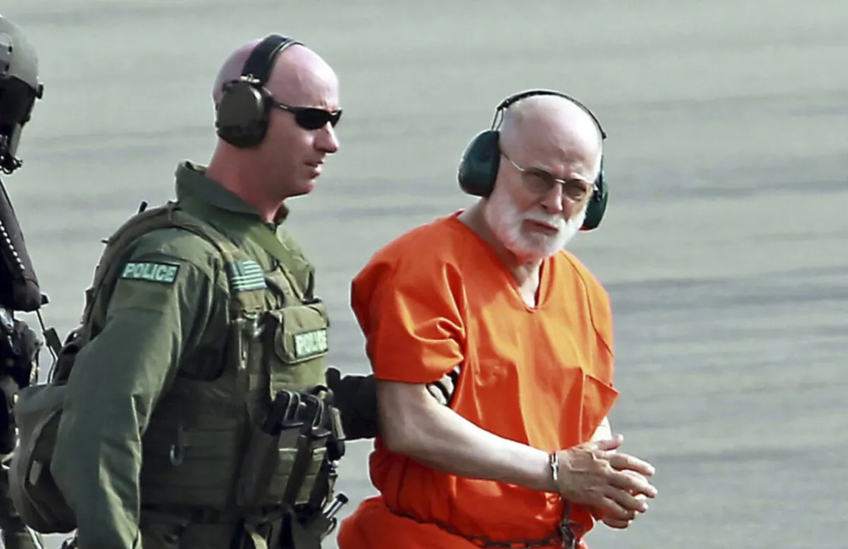 James "Whitey" Bulger (R) is escorted from a U.S. Coast Guard helicopter to a waiting vehicle at an airport in Plymouth, Mass., on June 30, 2011. (Stuart Cahill/The Boston Herald via AP)