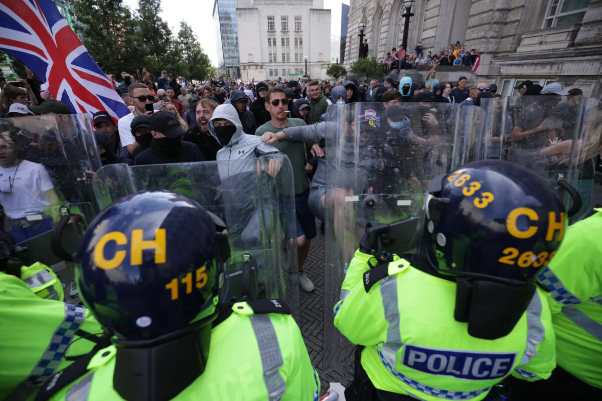 Police officers face protesters in Liverpool on Aug. 3, 2024. (James Speakman/PA Wire)