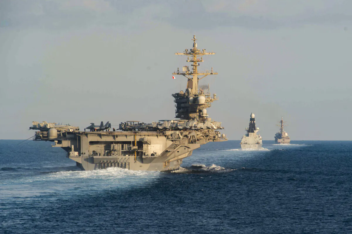 The aircraft carrier USS Abraham Lincoln (CVN 72) (L) the Royal Navy air defense destroyer HMS Defender (D 36), and the guided-missile destroyer USS Farragut (DDG 99) transit the Strait of Hormuz in this handout photo on Nov. 19, 2019. (Zachary Pearson/U.S. Navy via Getty Images)