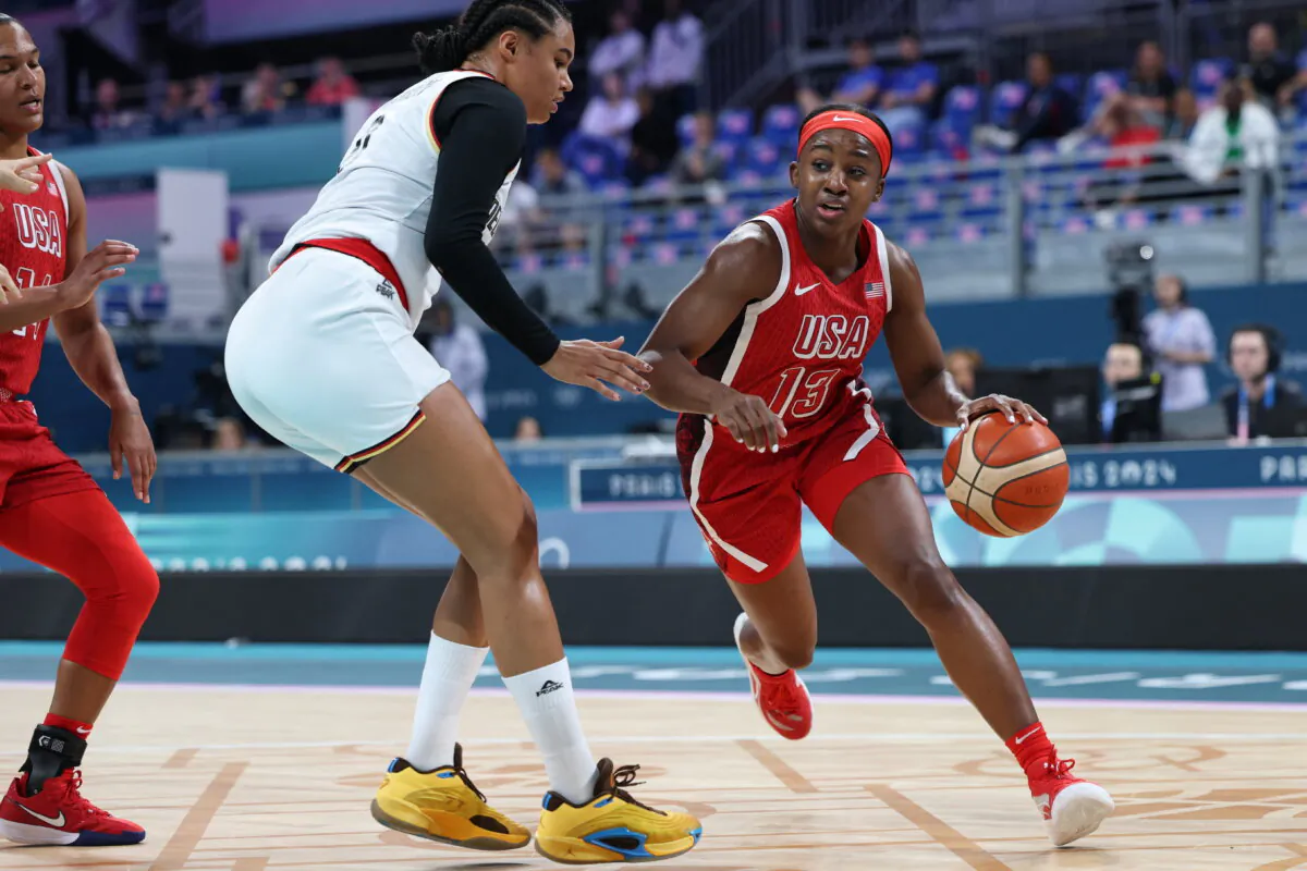 The United States' Jackie Young (13) works around Germany's Satou Sabally (0) in the women's preliminary round group C basketball match between Germany and the United States during the Paris 2024 Olympic Games at the Pierre-Mauroy stadium in Villeneuve-d'Ascq, northern France, on Aug. 4, 2024. (Thomas Coex/AFP via Getty Images)