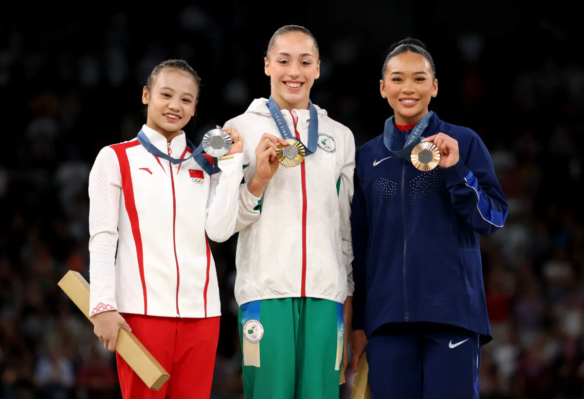 (L–R) Silver medalist Qiu Qiyuan of Team China, Gold medalist Kaylia Nemour of Team Algeria, and Bronze medalist Sunisa Lee of Team United States pose on the podium during the medal ceremony for the Artistic Gymnastics Women's Uneven Bars Final on day nine of the Olympic Games Paris 2024 at Bercy Arena, in Paris, France, on Aug. 4, 2024. (Jamie Squire/Getty Images)
